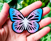 Monarch butterfly with a trans flag gradiant, representing the metamorphosis of transitioning.